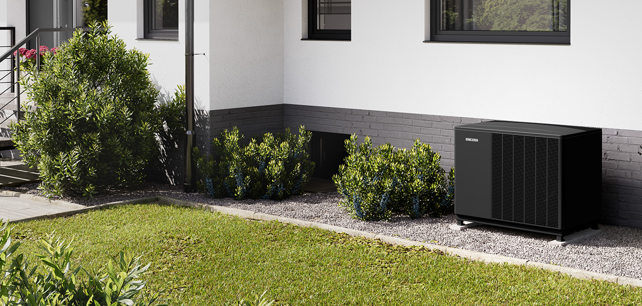 Une pompe à chaleur au propane qui est installée dans une bande de propreté d'un immeuble résidentiel. Le bâtiment est de conception moderne et l'espace extérieur est agrémenté d'une pelouse et d'arbustes.